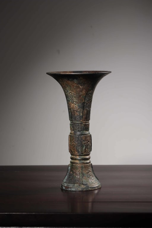Chinese Archaic Bronze Ritual Gu Vase: Dimension : 21cm H x11.7cm w,weight is 724gram. The central raised band and the flared lower section are cast with highly stylized Taotie (mythical gluttonous beast) masks.