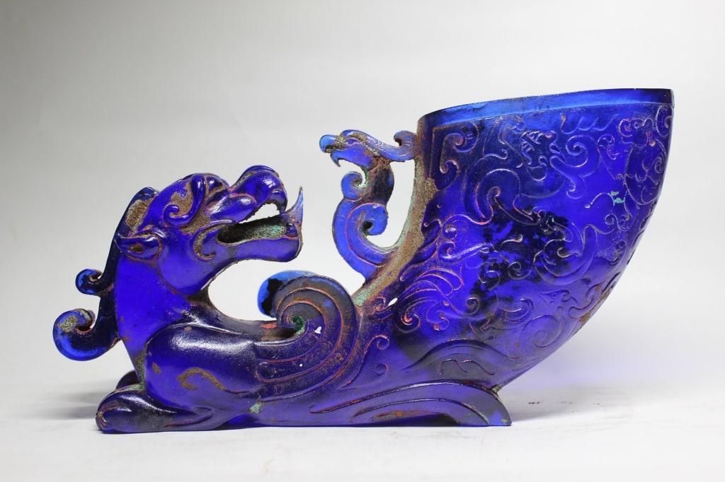 Chinese Cobalt blueHorn-shaped drinking cup vessel: Dimension : 7 1/2"L The horn portion curves upward from the creature's tail and is deeply carved with low-relief archaic scrollwork motifs. These low-relief patterns mimic the traditional taotie or