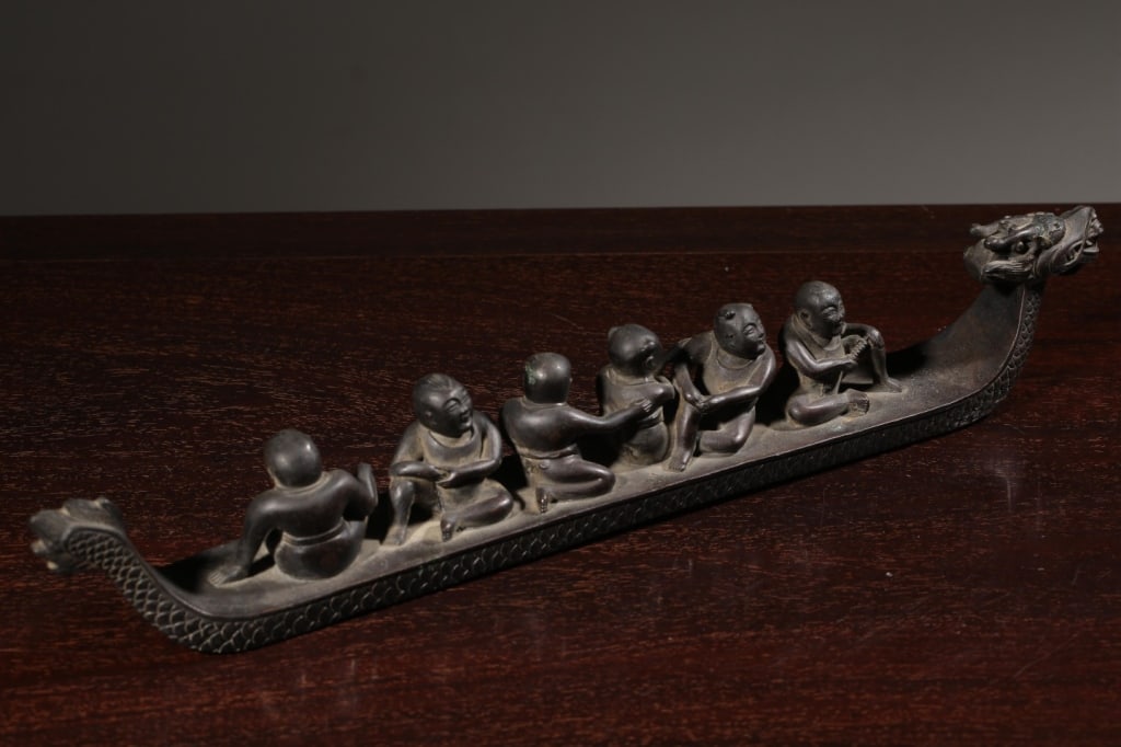 Chinese Bronze Dragon Boat with children.: Dimension : 35cm L x 3.5 x5cm,weight is1374.3gram. The object is sculpted into the long, slender silhouette of a traditional dragon boat (longzhou).
