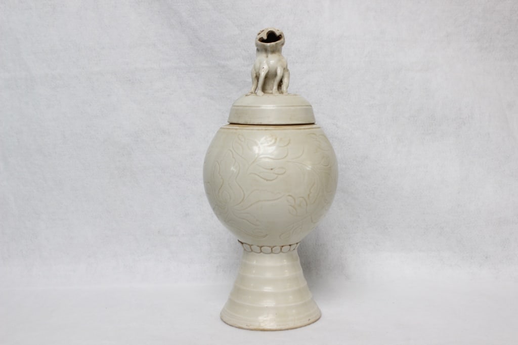 Chinese white-glazed porcelain lidded jar: Dimension: 11 1/2"H. The lid is topped with a hand-carved animal finial, typically representing a Buddhist lion (Foo Dog) or a beast, which acts as a handle for the cover.