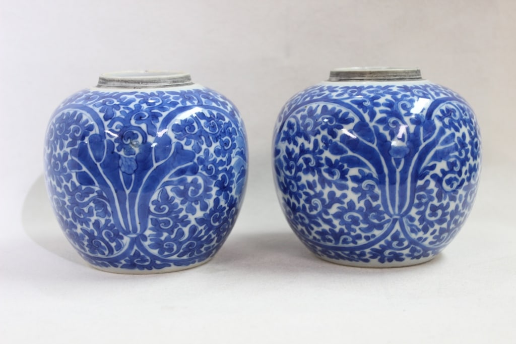 pair of Chinese blue and white porcelain jars: The jars are decorated with a dense lotus blossom and scrolling vine (foliate) motif. This scrolling pattern is a classic element of Chinese ceramic art, often symbolizing longevity and continuous gro