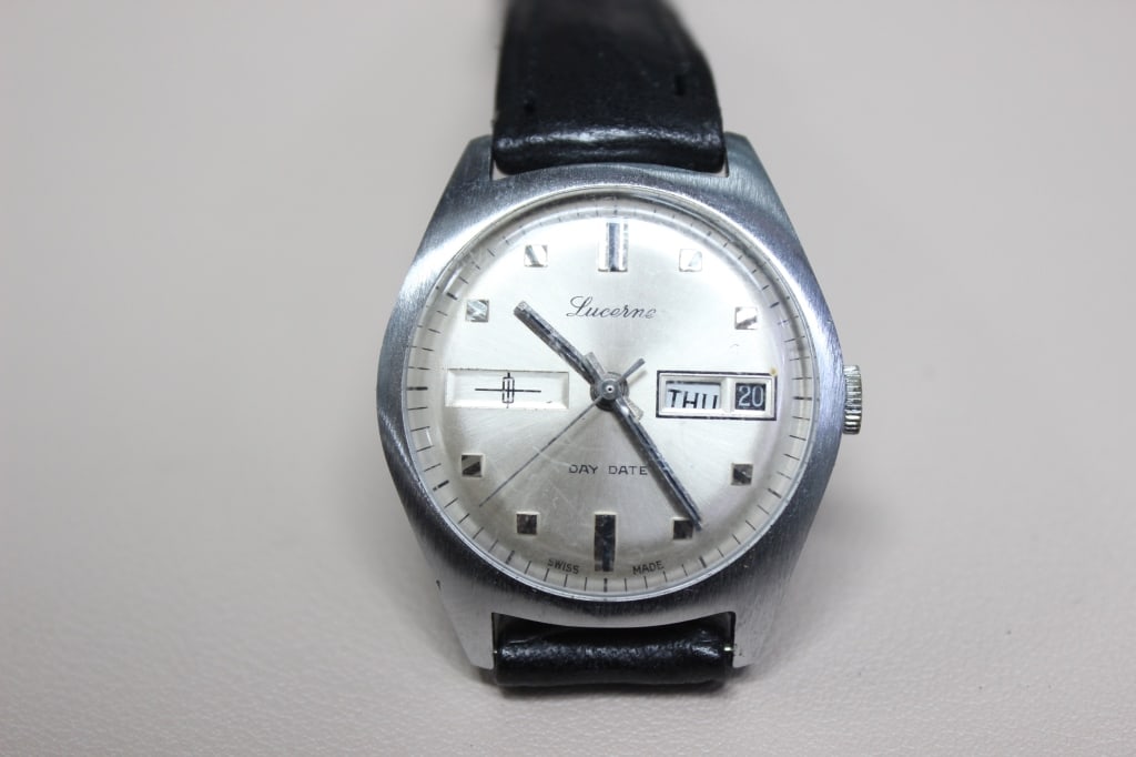 vintage Lucerne Day-Date wristwatch: vintage Lucerne Day-Date wristwatch, a classic mechanical dress watch likely dating from the late 1960s to the 1970s. It features a brushed stainless steel (or chrome-plated) case with a traditional