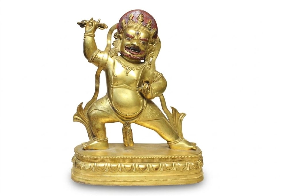 Chinese gilt bronze sculpture of Vajrapani: Dimension:8"x 10 1/2". The Buddha stands in pratyalidha (an active, lunging warrior stance) atop a single-layered oval lotus base edged with fine beading .His raised right hand brandishes a vajra (thu