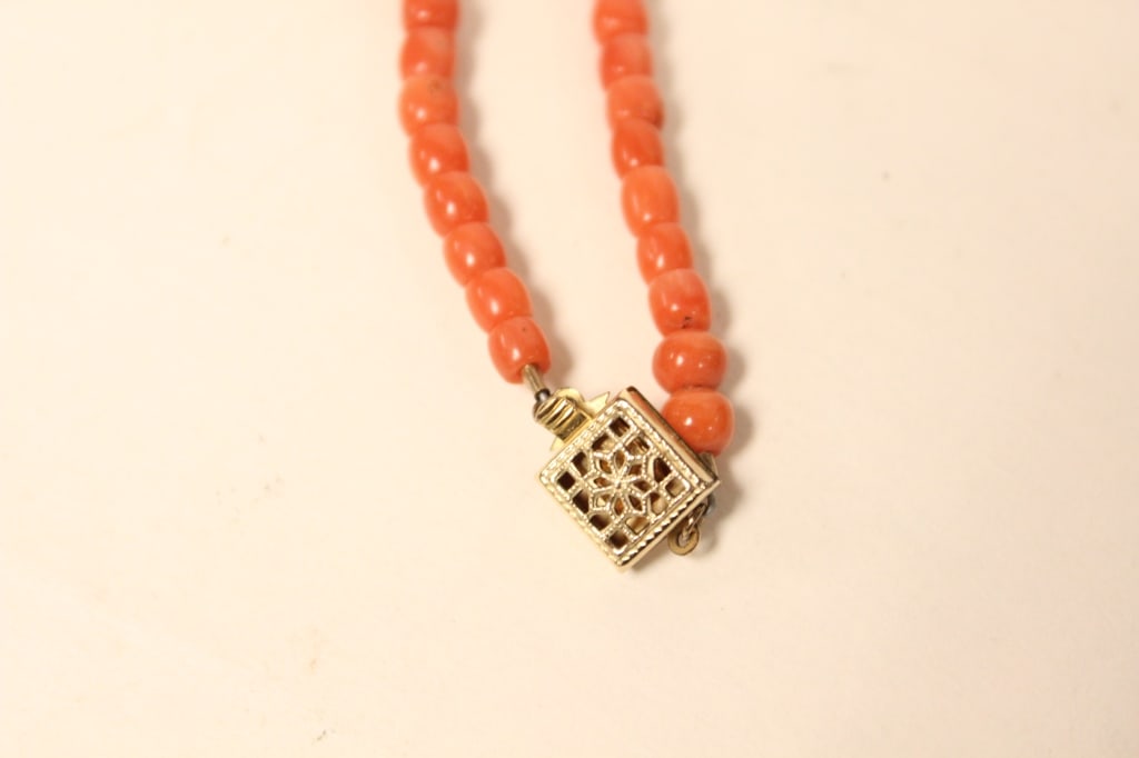 Vintage Coral Bead Necklace: Dimension: 13 1/2"Long. Necklace is made from graduated natural coral, secured with a clasp. The clasp is a box-style closure with an ornate, filigree floral pattern in yellow metal.