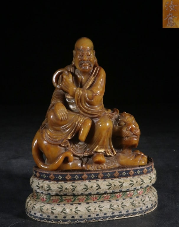 Chinese Hand-carved Shoushan stone statue of: Chinese carved Tianhuang Shoushan stone statue of the Tiger-Taming Arhat Dimension: 13.5cm H x 12.6cm L x 6cm,weight is 910gram. The statue depicts Pindola Bharadvaja (or