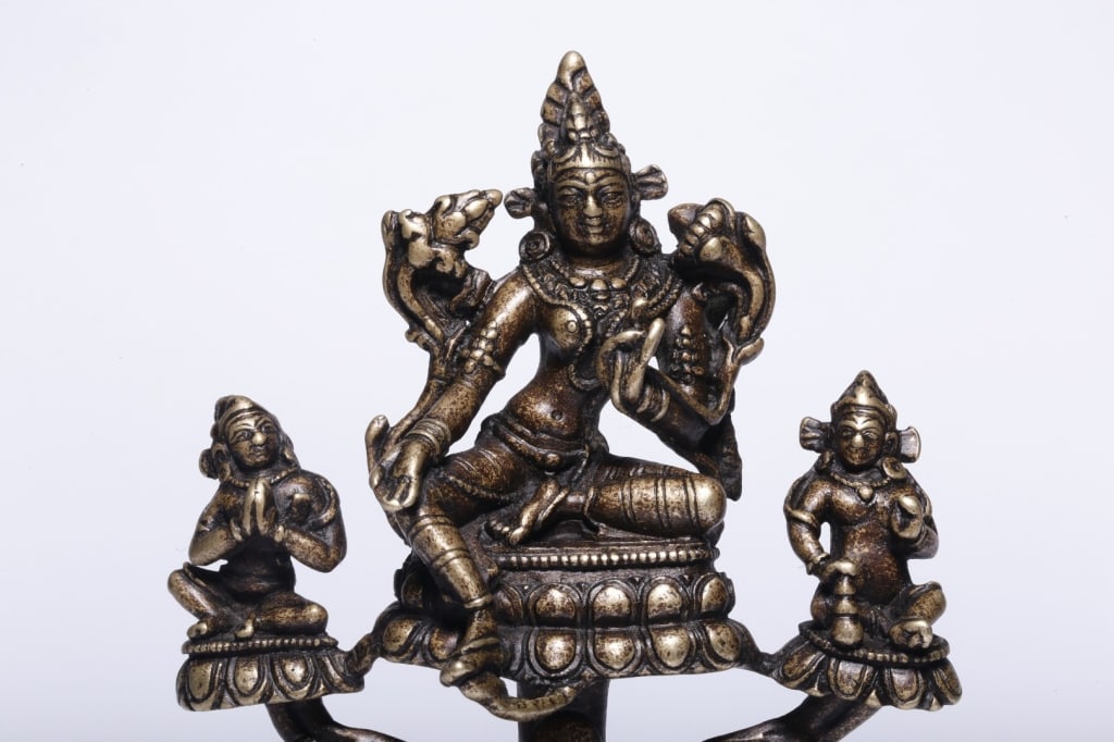 Asian Mix-Metal Bronze icon depicting Green Tara: Dimension: 13.5cm H x 9 x 5.6cm,weight is 428gram. Tara is seated on a central lotus throne in the posture of royal ease (Lalitasana). Her left leg is folded inward in meditation, while her right leg 
