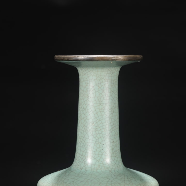 Chinese monochrome celadon-glazed mallet vase: Chinese monochrome celadon-glazed mallet vase. Dimension: 23cm H x 12cm w . The vessel is crafted with a slightly tapering cylindrical body, crisp angled shoulders, and a tall, slender neck that flare