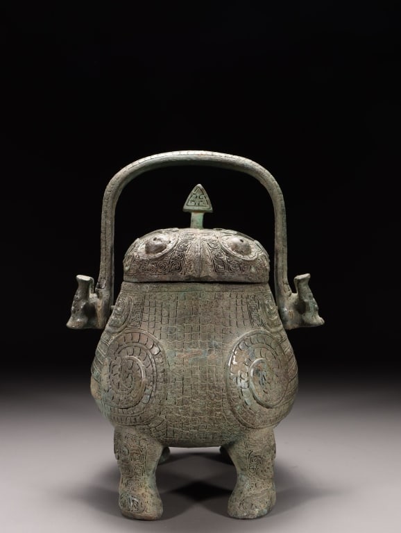 Chinese ritual bronze wine vesselknown as a you (?: Dimension: 22cm H x 15cm L x 14cm W,weight is 2600gram. The vessel features a pear-shaped, rounded body supported by four short, stout legs, completely covered in low-relief decoration against a fine