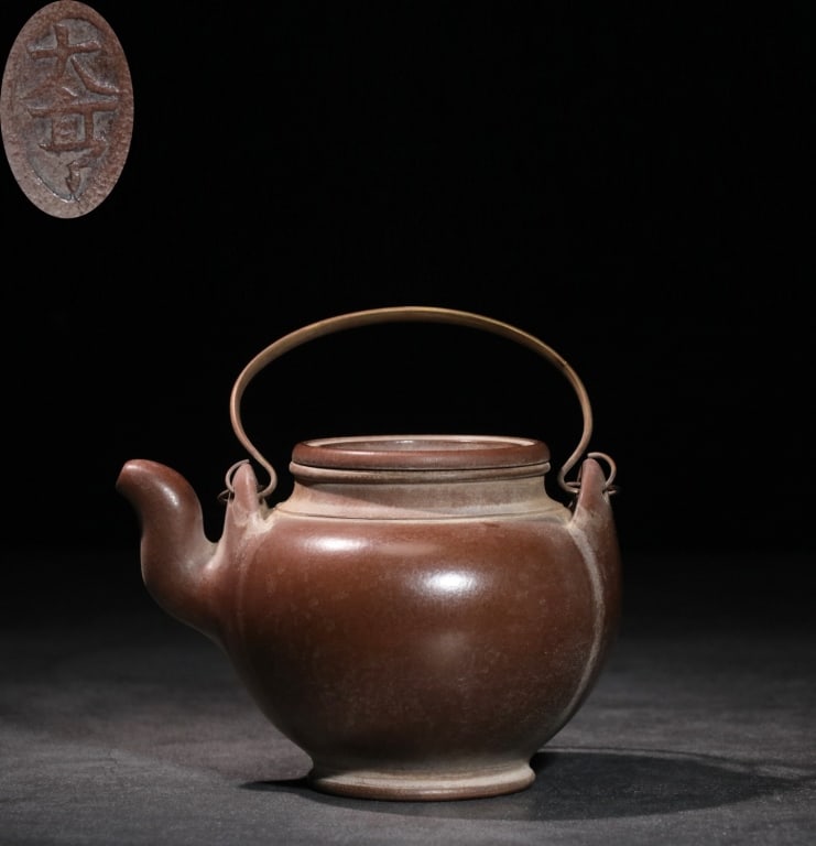 Chinese Yixing zisha clay teapot,Mark: Dimension: 9cm H x 13.5cm L x 10.7cm w. The vessel is crafted from a fine, dark purple-brown zisha clay, modeled into an elegant, robust globular form with a short, curved spout and a inset lid. The o