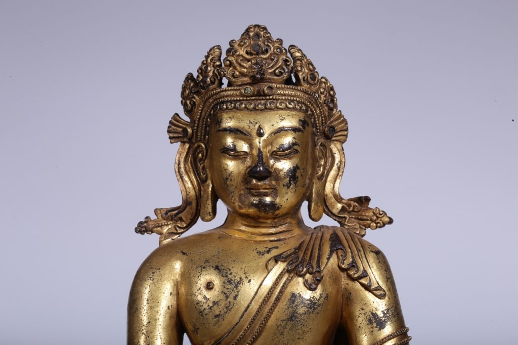 Chinese gilt bronze statue of Akshobhya Buddha: Chinese gilt bronze statue of Akshobhya Buddha. Dimension: 29cm H x 21cm L x 15,weight is 4661gram. The figure sits in full dhyanasana (lotus position) upon an ornate, double-layer lotus