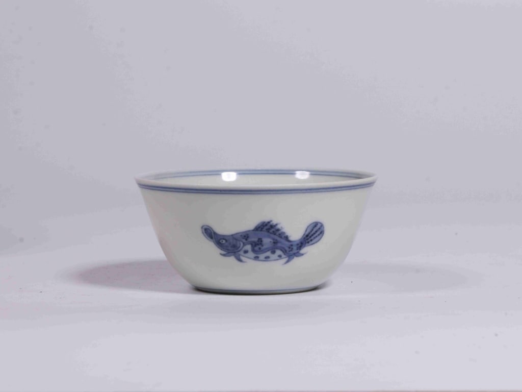 Chinese blue and white porcelain "Fish" bowl,Mark: Dimension:8cm w x 5cm H , The exterior wall features a single, detailed carp or mandarin fish swimming through open space, framed by simple double-ring borders at the rim and base.