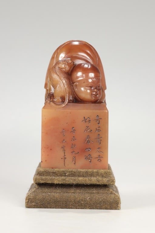 Chinese carved Shoushan Stone Seal w Boy Finial: Chinese carved Shoushan stone seal Dimension: 8.5cm H x 4.3cm w,weight is 337g The top knob is skillfully sculpted in high relief to depict a plump, smiling Chinese infant or boy