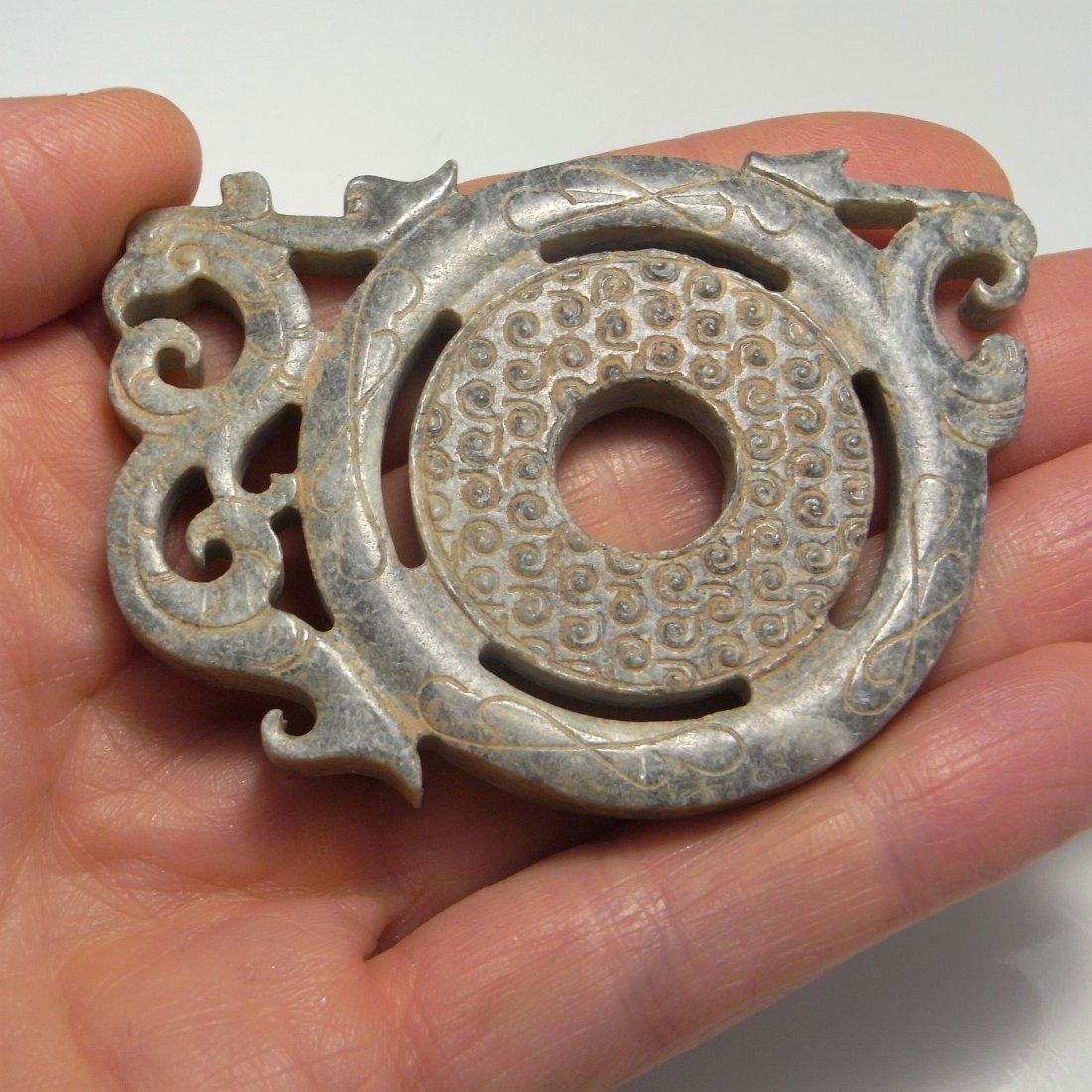 206BC -220AD Han Dynasty Antique Jade Phoenix Amulet: Here we have an ancient Chinese jade phoenix bi disc amulet dating to the Han Dynasty 206 BC to 220 AD. The jade here opaque in mottled gray tones front and back the coloration across the whole of exc