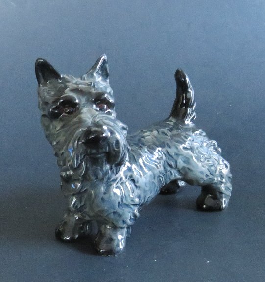 Terrier Porcelain Dog Figurine Goebel Germany: A Terrier, porcelain dog figurine by Goebel, Mid-Century. The original paper label is present, "Goebel" with Hummel trade mark and "Made in W. Germany" [West Germany]. The marking 'W. [West] Germany'