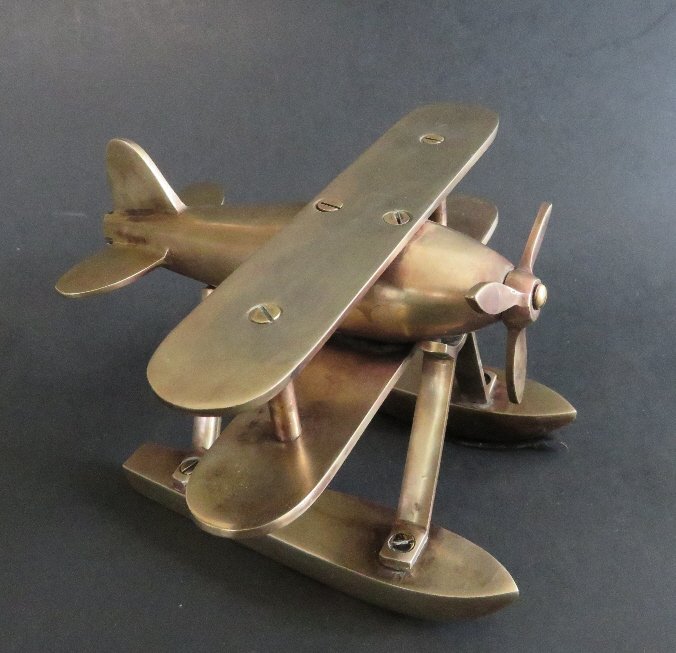 Art Deco Handmade Biplane, Seaplane, Solid Brass: Art Deco handmade sea-biplane, solid brass, probably 1930s, desk decor, paper weight. The plane consists of several screwed together solid brass parts. The propeller is movable--can rotate. Signs of a