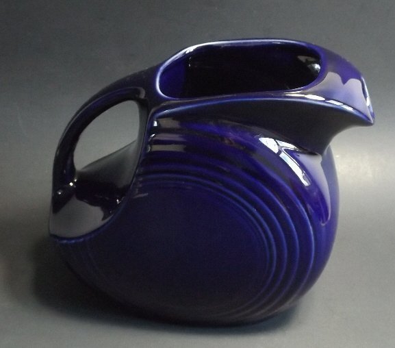 Large Fiesta Pitcher Art Deco Cobalt Blue 1980s: Large [1/2 gallon] Fiesta pitcher in the original cobalt deep blue glaze. There is mark on the bottom "HLC fiesta MADE IN USA" with added "H" and no date code inside a triple band of concentric rings.