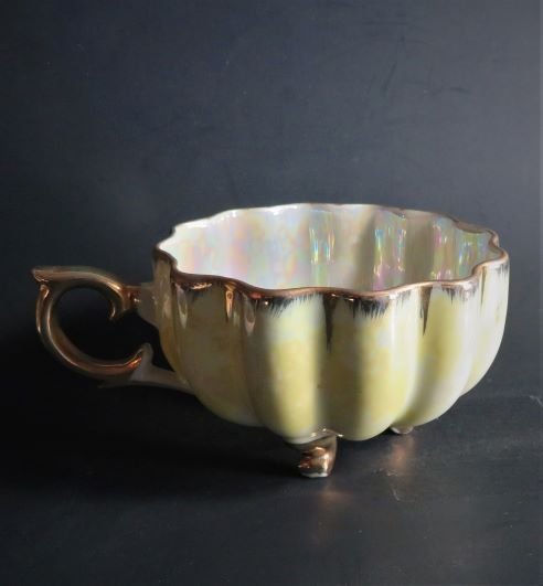 Antique Rococo Iridescent Mother of Pearl Porcelain Tea Cup & Saucer: Antique Rococo style scalloped and fluted footed tea cup. Iridescent mother of pearl glaze with 'love scene' cameo inside, yellowish luster glaze overcoat outside, gold rim, handle and feet. Unmarked.
