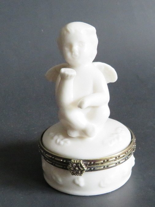 Mid Century Angel Amour Milk Glass Jewelry lidded Trinket box 1950s: Vintage Mid Century Angel / Amour blowing a kiss, small jewelry or trinket box, milk glass with brass rim and brass hinge, unmarked, c. mid-20th century. The box is c.2” across, 3.1/2” tal