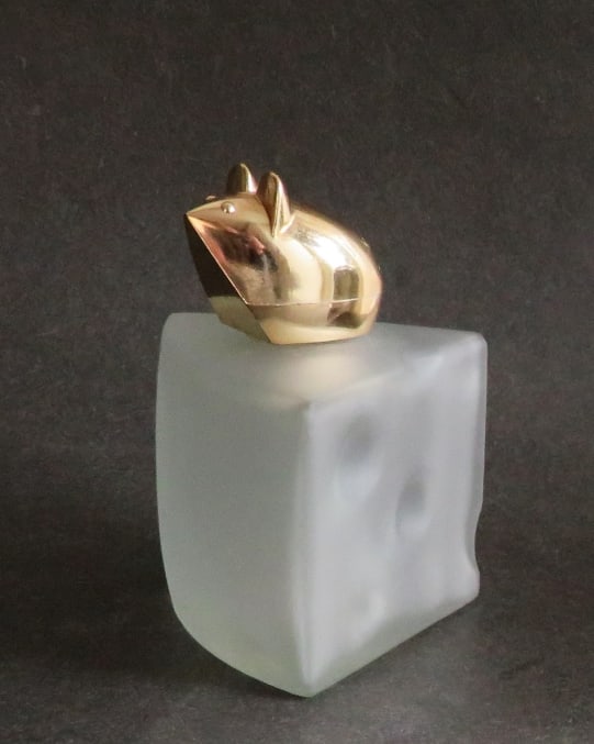 Vintage Avon Swiss Mouse On Cheese, Field Of Flowers Cologne Bottle 1970s: Vintage Avon "Swiss Mouse" [Mouse on Swiss Cheese] empty cologne bottle, 1970s, the original paper label on bottom is present. Little golden plastic mouse on an opaque frosted glass wedge of cheese; c