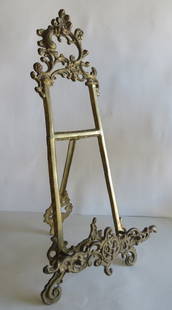 Antique French Rococo Style Orante Gilt Brass Metal Picture Easel: Antique French Rococo style gilt brass metal easel, unmarked. The easel is 20" tall [51cm], 9.1/2" [24cm] wide, extended up to 10" [25.5cm] long. The shelf for the picture [or book] display is 1.1/2"