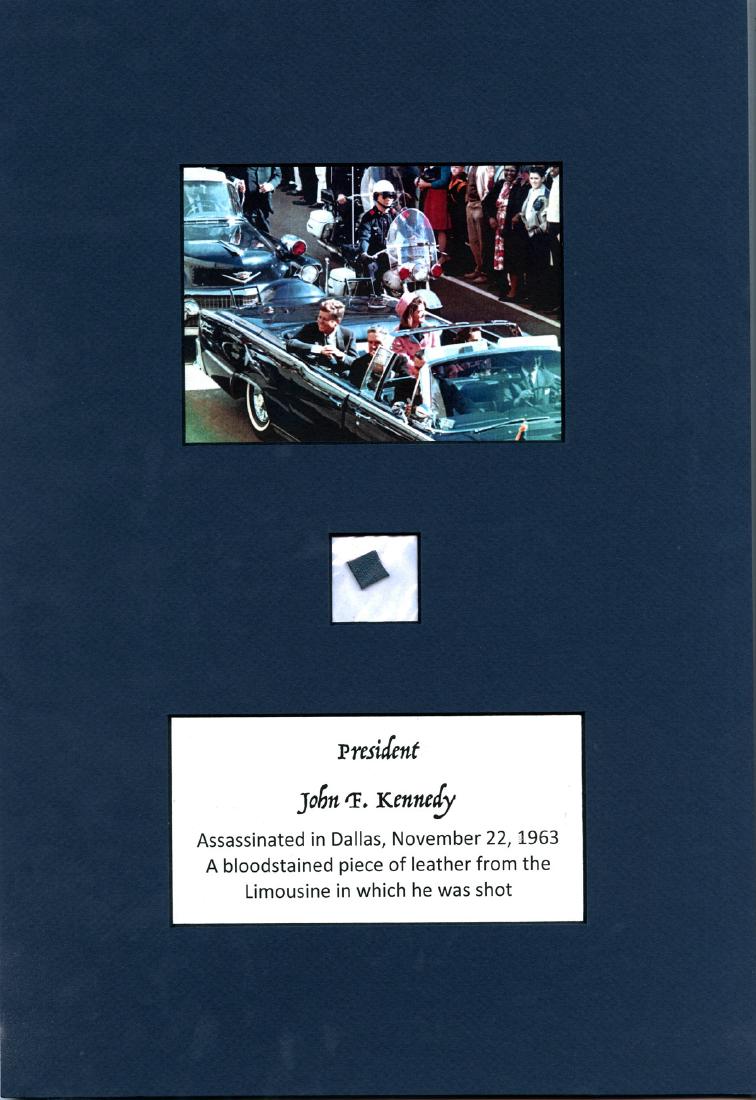 John F. Kennedy, Original Blood-stained Leather: Description: Kennedy John John F. Kennedy, Original Blood-stained Leather Fragment from Dallas, Texas Limousine A .625" x .375" swatch of blood-stained navy blue leather upholstery removed from JFK's 