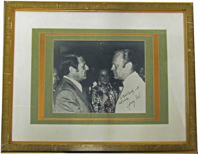 Gerald Ford Signed Photo: Gerald Ford Signed Photo Signed black and white photo of Gerald Ford in profile, featuring wife Betty Ford pictured in center background. Boldly and affectionately signed "Jerry Ford" in bottom