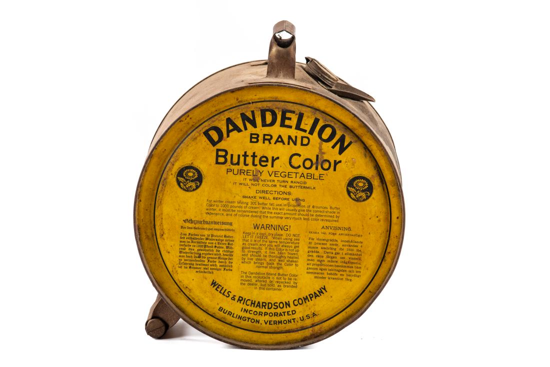 Dandelion Butter Color 5 Gallon Rocker Can: A can from the Wells & Richardson Company Burlington, Vermont. It shows areas of discoloration, wear, and run marks on one side. It displays well with the dandelion graphics. Measures: 5 gallon Rating