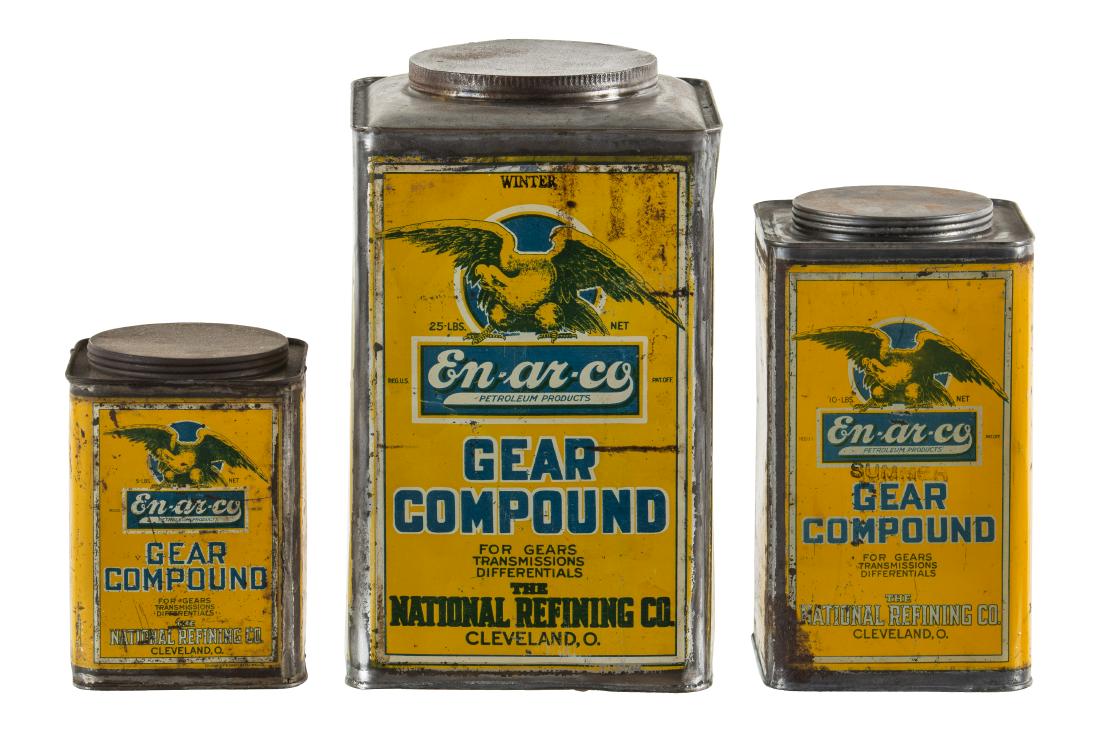 Lot Of Three Early En-Ar-Co Gear Compound Cans: They have average color. They show areas of discoloration, wear, paint loss, and dents. They display well with the early logo. Measures: 7.25"x5"-13.5"x8" Rating: 7-6.5 Est: $250-$500