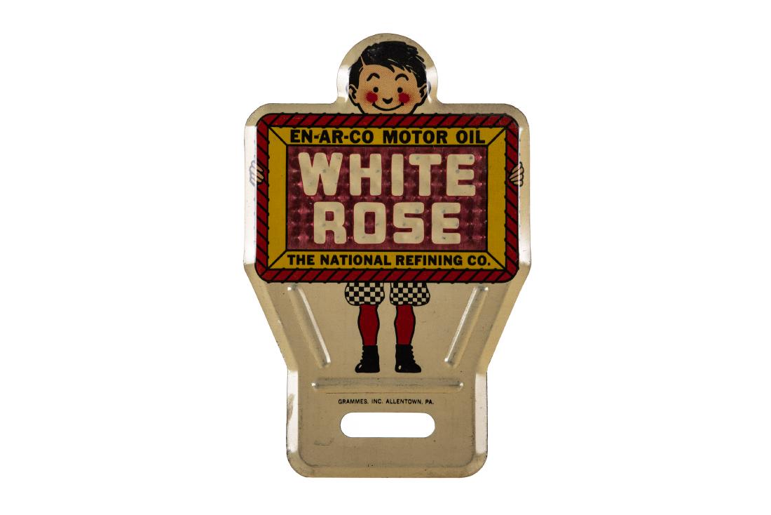 1930's Enarco White Rose License Plate Topper: N.O.S. SST with reflective field. Great gloss and color. Shows only very minor flaws. Marked Grammes. Inc. Allentown PA. Doesn't get any nicer than this one. Measures: 6"X3.75" Rating: 9.5 Est: $200-$