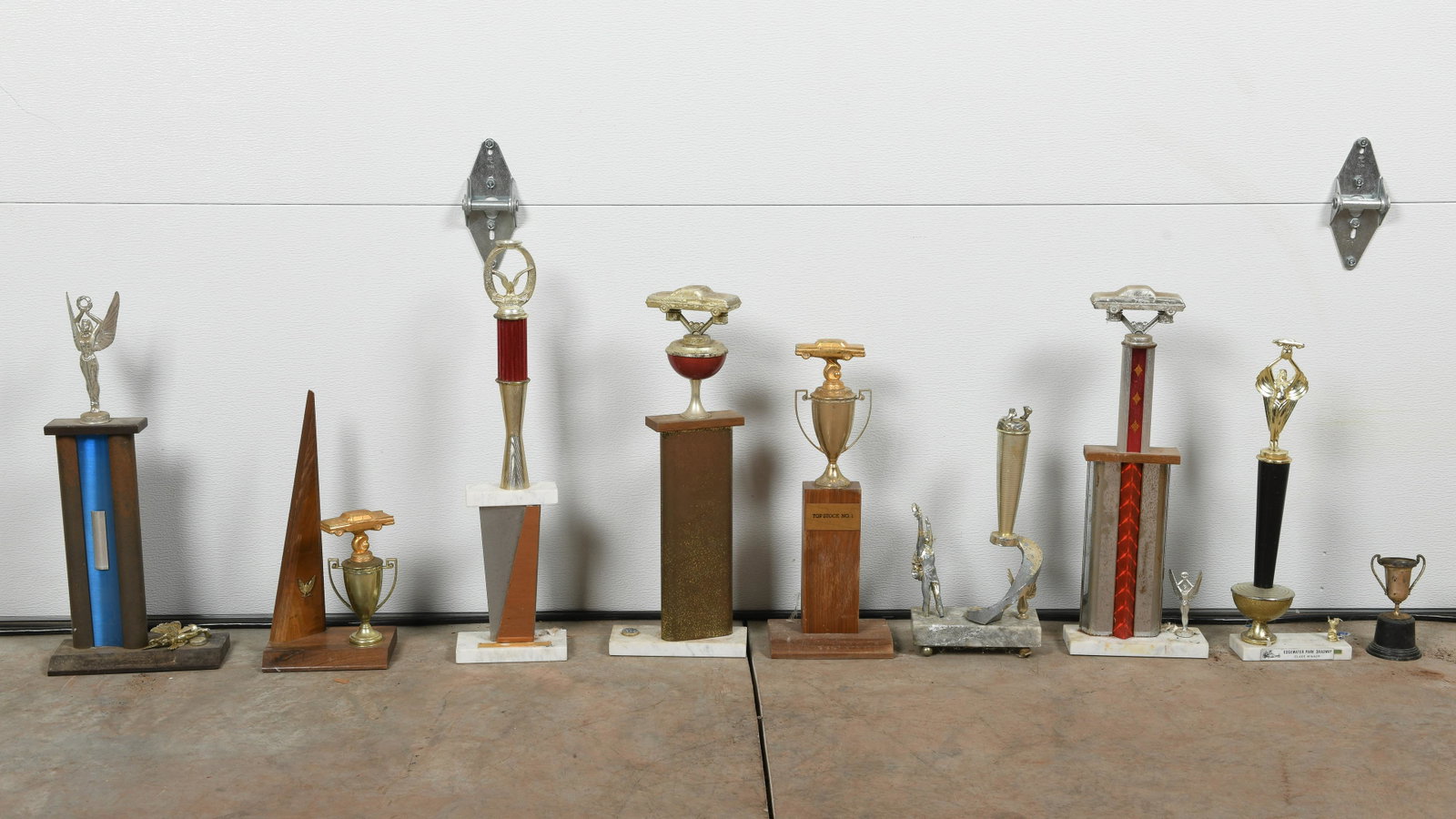 Lot Of Nine Automotive Trophies: Lot of assorted trophies. Some show damage. Measures: 21"X7"/ 6"X3" Est: $100-$300