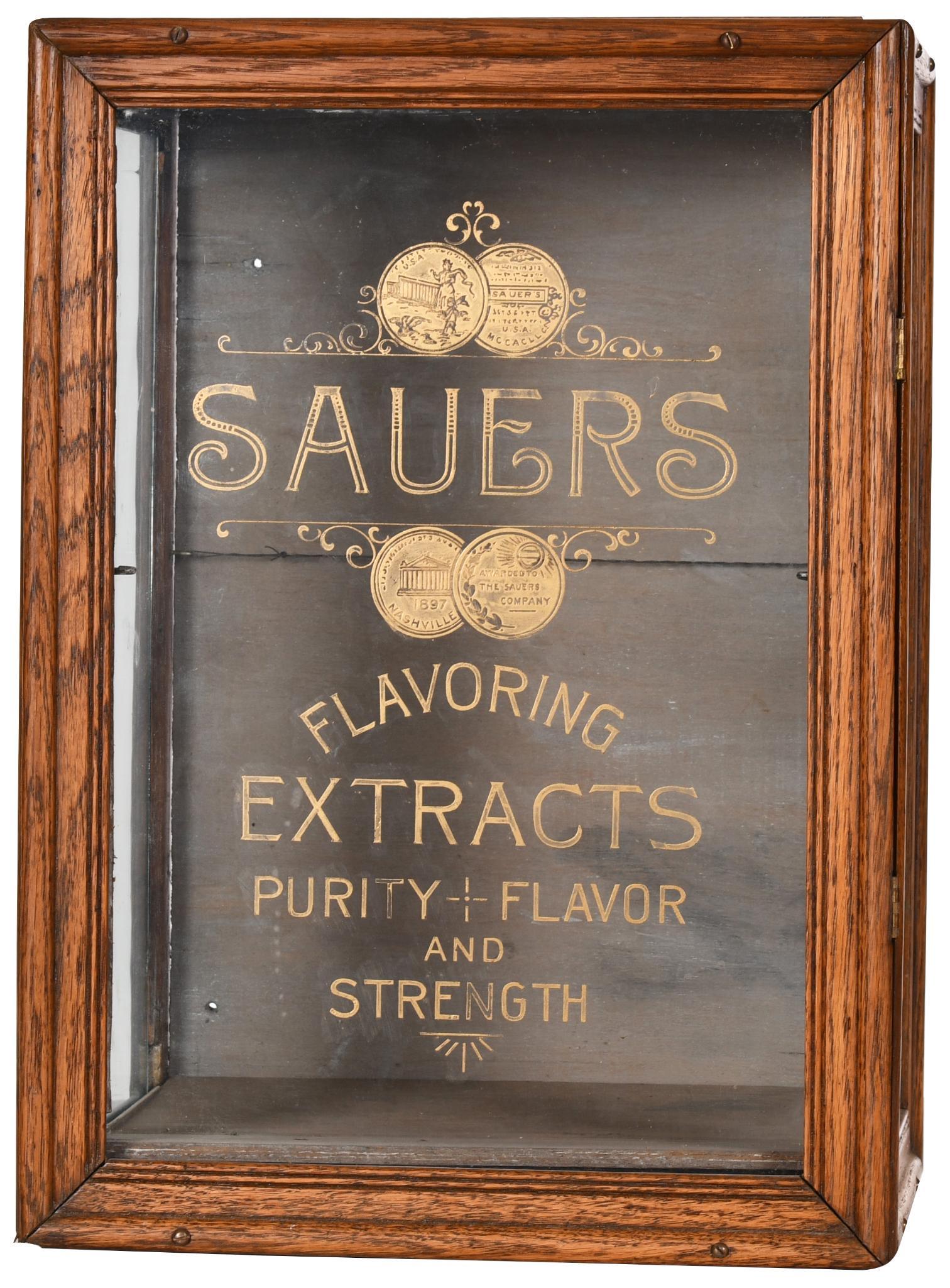Small Sauer's Flavoring Extracts Display Case: The lettering is reverse painted on the glass. It shows some wear, discoloration, and warping to the top, inner, and reverse wood. The front has been screwed shut. It displays well. Overall average co