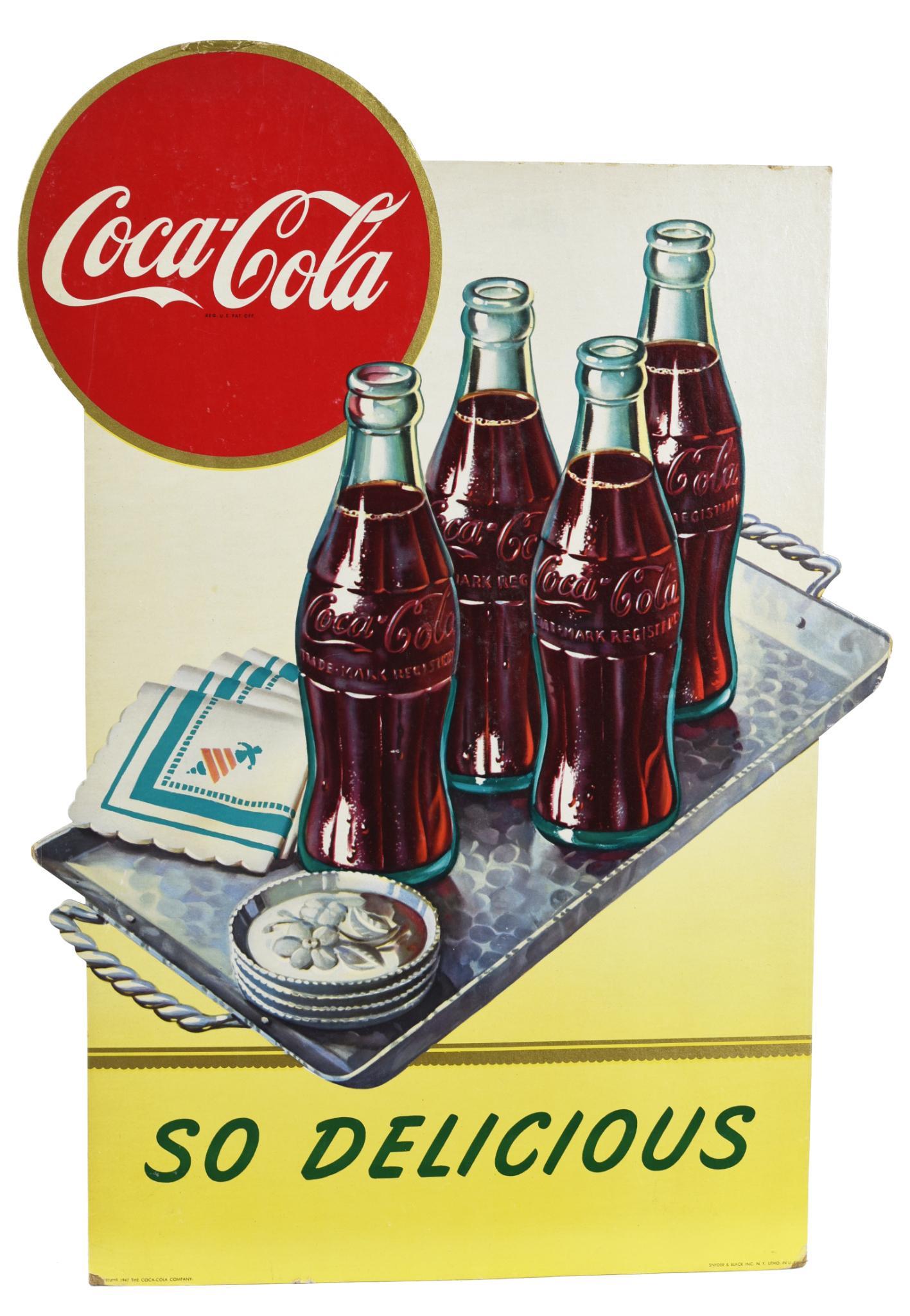 Coca-Cola "So Delicious" w/Coke Bottles on a Tray Sign: Single-sided diecut cardboard sign, has good color and shine, field is clean has edge wear, marked Snyder & Black Inc. NY, 23"x15", rated 8.5