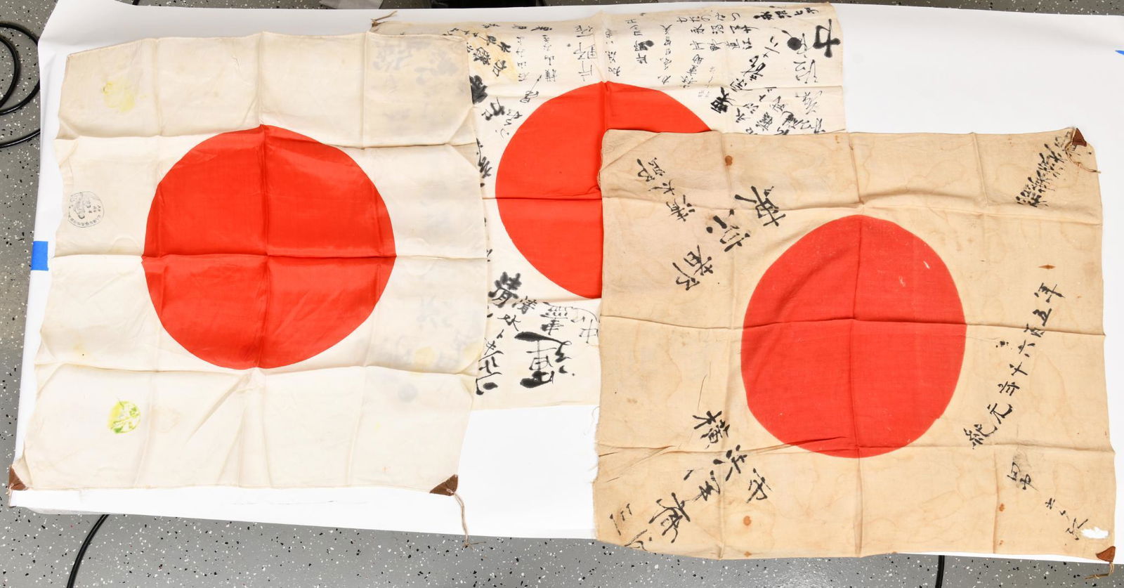 Lot Of 3 Japanese Flags: All three have good color. One shows more staining than the others. Nice lot of early flags. 27"X30"