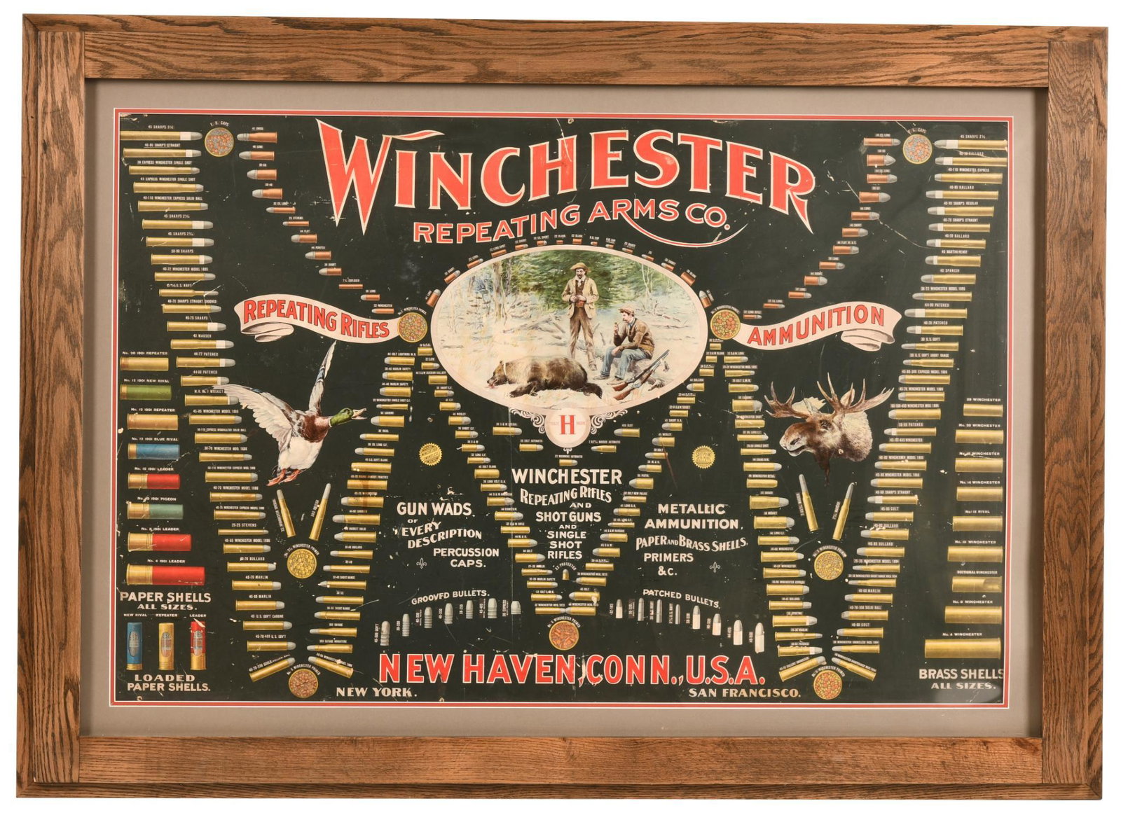 1902 WINCHESTER AMMUNITION DISPLAY BOARD: Framed. Heavy Cardboard. Shows Some Wear, Discoloration, Creases, And Some Small Nail Holes. Displays Very Well And Is An Extremely Hard Piece To Find. 41"x57". Above Average Overall Condition.