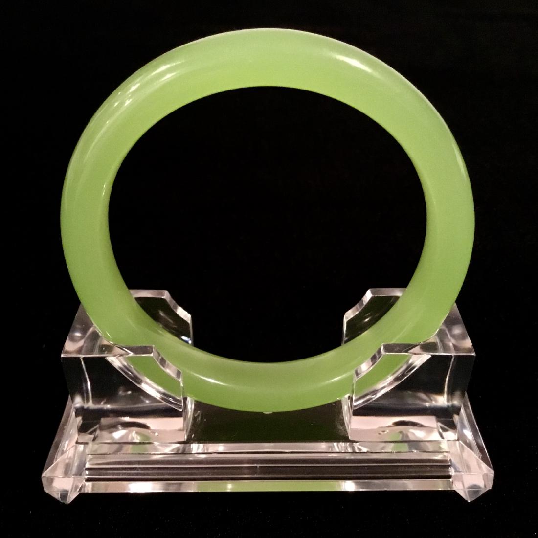 JADE BRACELET: A CHINESE LEMON GREEN JADE BANGLE. SIZE: 62 mm