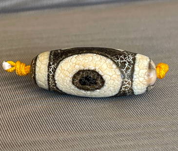 A TIBETAN DZI BEAD: SIZE: 11 X 30 mm
