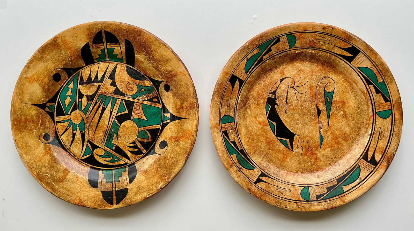 Signed Southwestern Studio Pottery Wall Plates – Hand Painted Set of 2: Set of two hand-painted pottery wall plates signed by the artist.These large 16” ceramic plates feature bold Southwestern-style motifs inspired by Native American designs, with geometric, abstra
