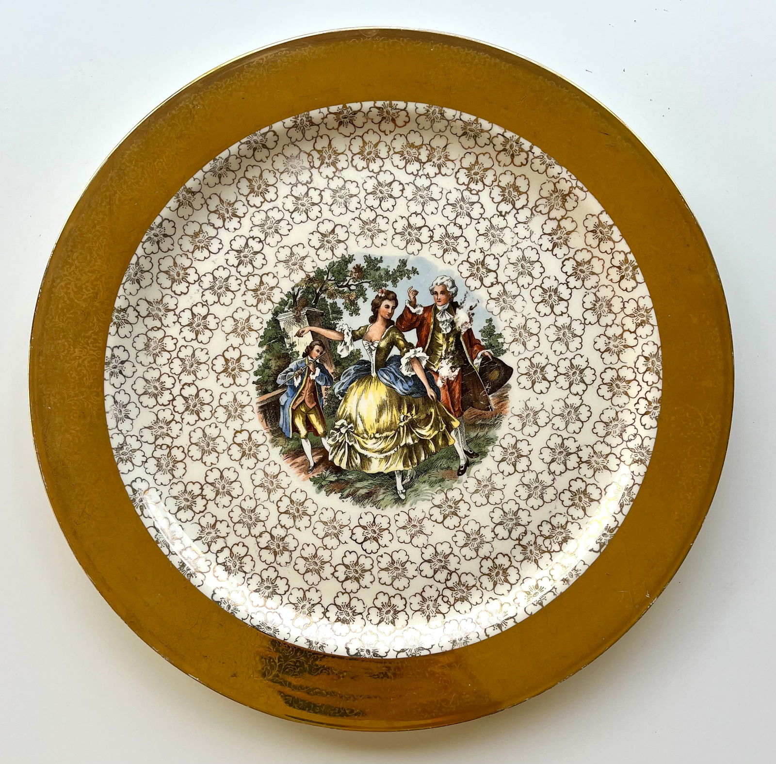 Vintage Royal USA Eggshell Nautilus Plate 14??- 22 KT Gold Rim Colonial Courting: Beautiful vintage 14” decorative plate by Royal USA (Eggshell Nautilus line), featuring an 18th-century courting scene and a wide 22K gold floral rim. Made in the USA circa 1940s–50s. Marked