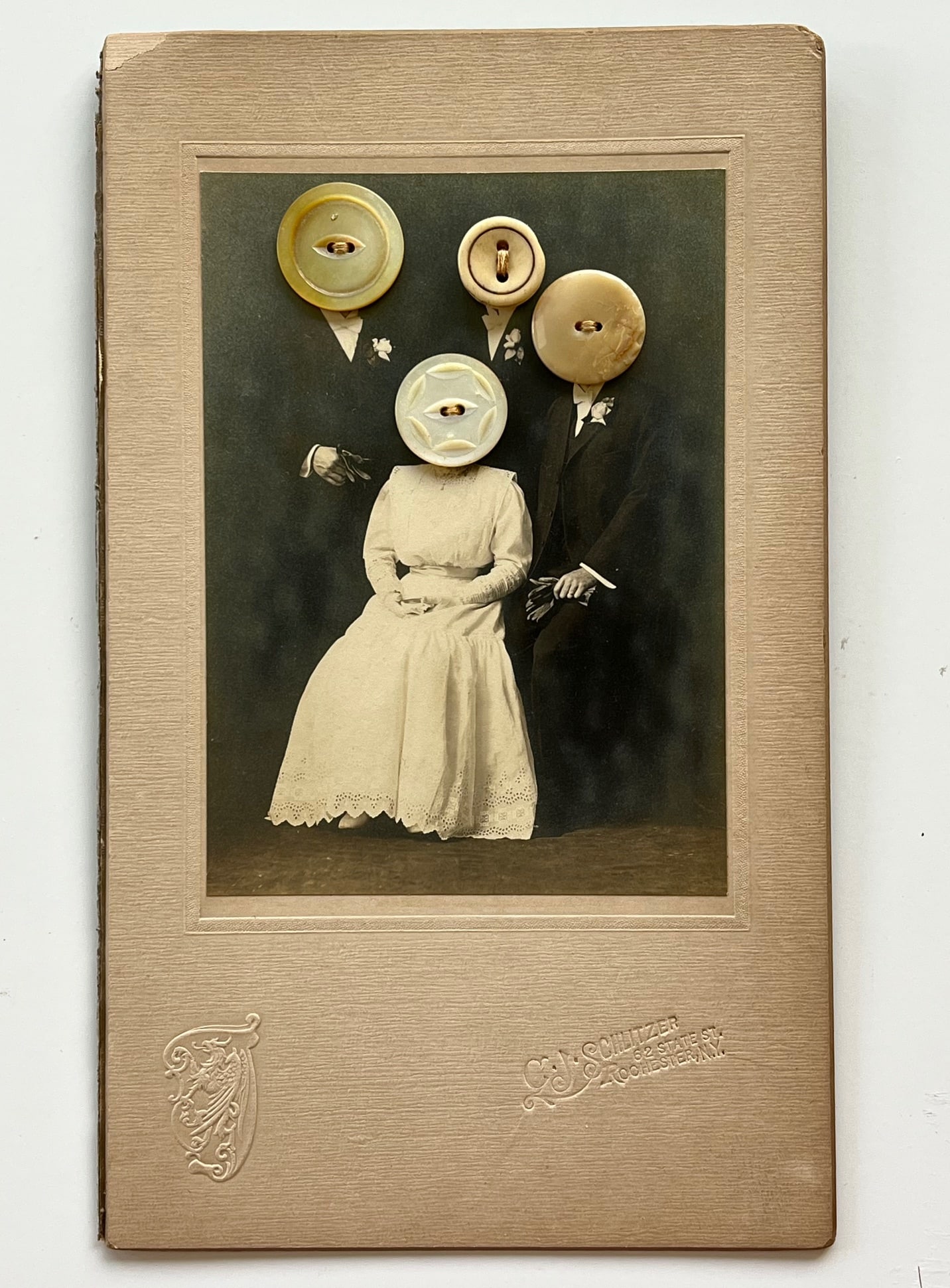 ANTIQUE EERIE OUTSIDER FOLK ART RARE GOTHIC PHOTO COLLAGE W BUTTONS: Antique eerie outsider folk art photo collage featuring an antique studio portrait altered with sewn-on buttons replacing the subjects’ faces. Mounted on original card stock with visible stitching o
