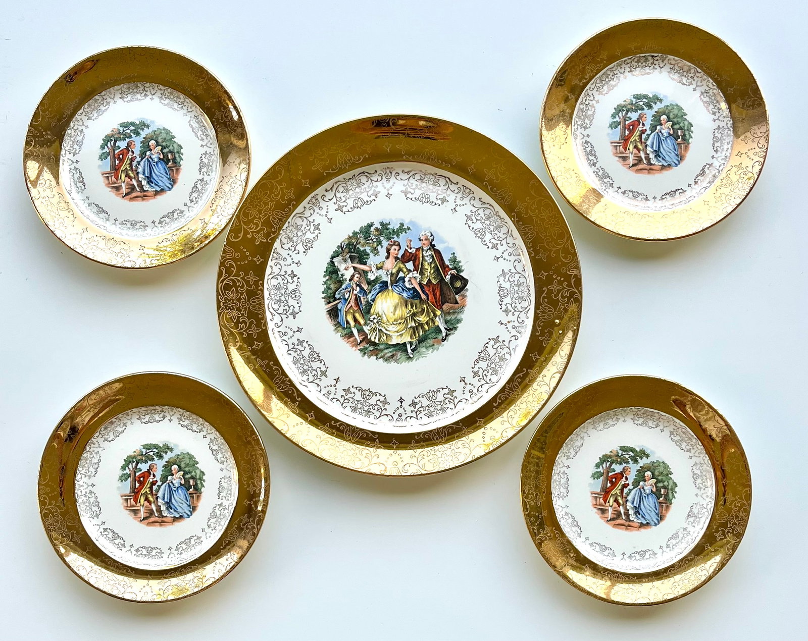 Set of 5 Victorian Style W.S. George Derwood Plates – Romantic Scene & 22K Gold Trim: Beautiful vintage decorative plates by W.S. George in the Derwood pattern. Features a romantic colonial courting scene at the center, surrounded by ornate floral filigree and a wide 22K gold-trimmed b