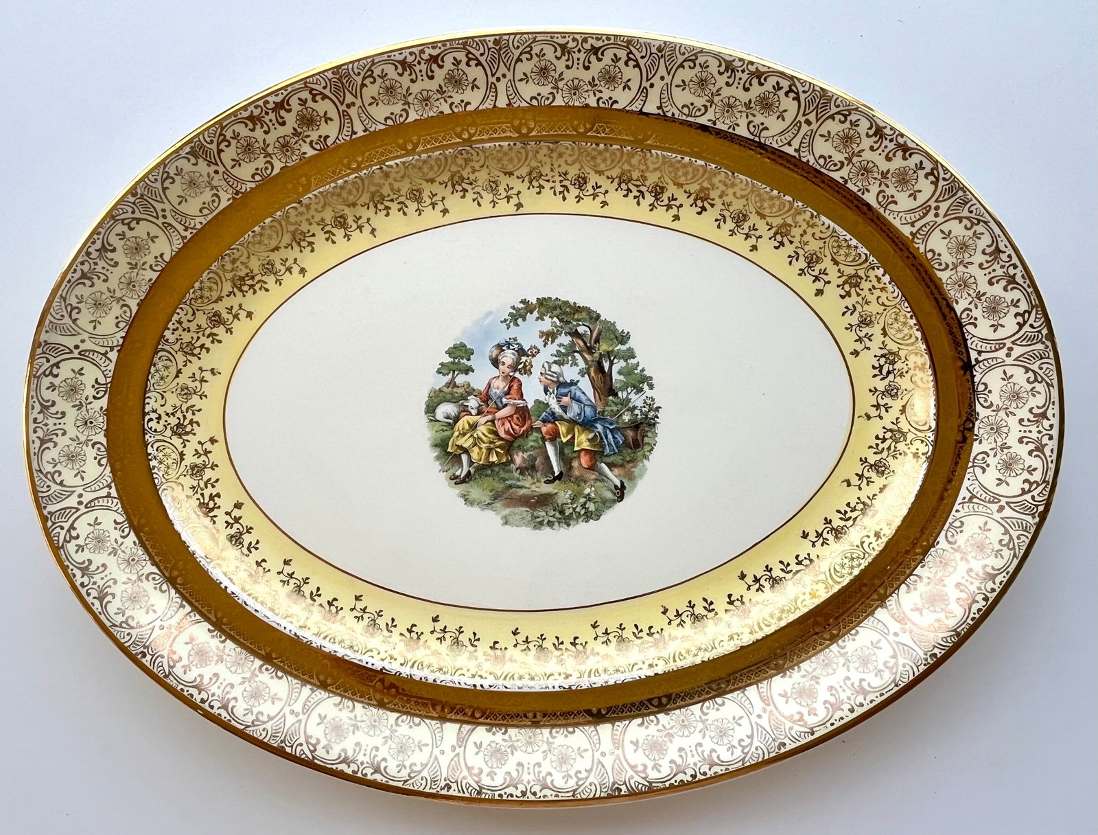 Victorian Style Bromley 15?? Oval Platter – Rococo Courting Scene, Gold Trim: Beautiful vintage porcelain serving platter by Bromley. Features a romantic Rococo-style courting couple at center, ornate gold floral trim, and rich yellow border. Measures approx. 15 inches .
