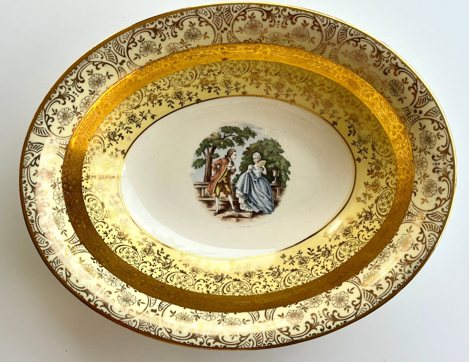 Victorian Style Porcelain 22k Gold Bromley Oval Serving Bowl – Gilded Rococo Couple Scene 9 in: Elegant vintage oval porcelain and 22k gold bowl by Bromley, dating to the 1950s–1970s. Features a Rococo-style romantic couple scene at center, richly detailed gold floral and scroll trim, and