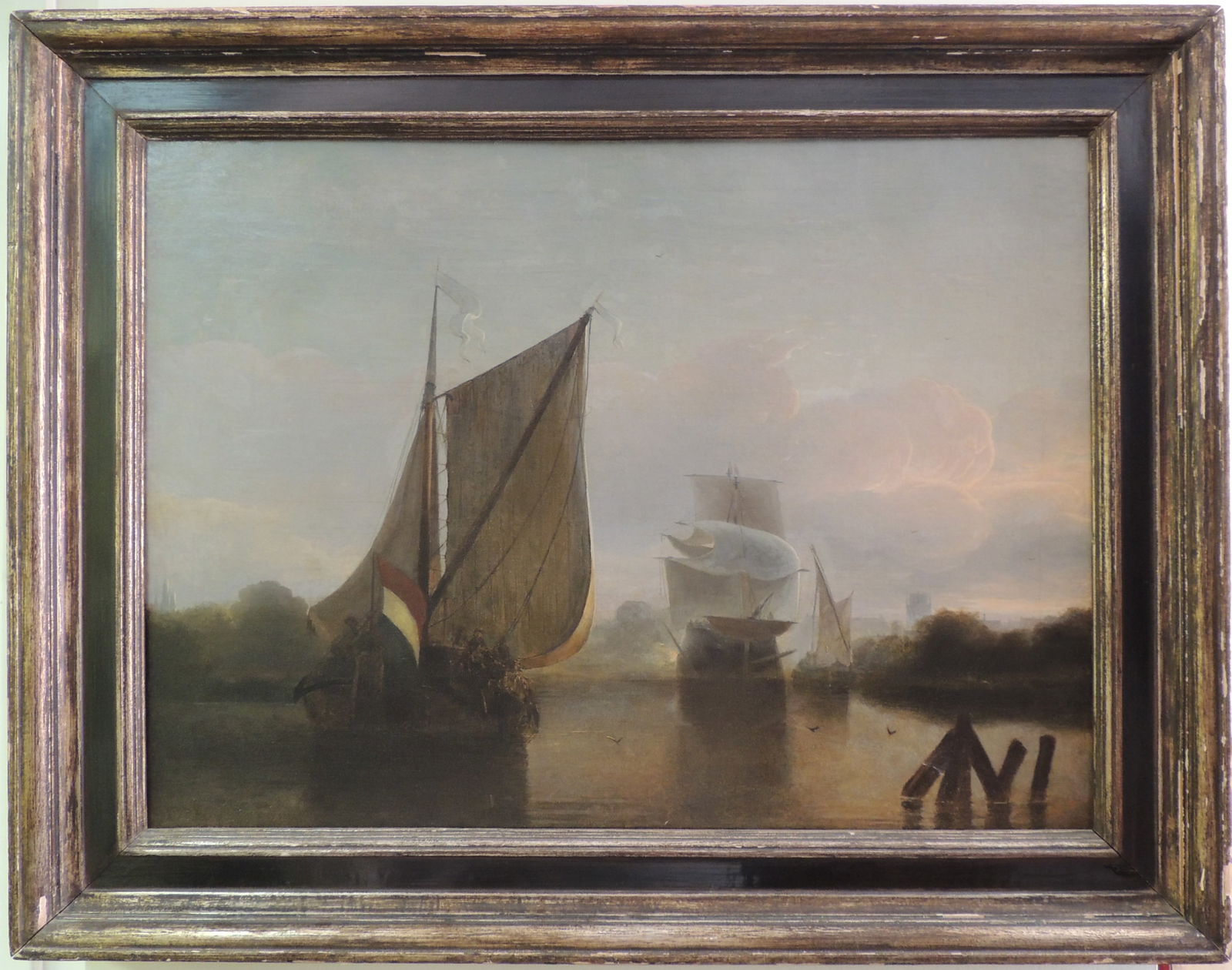 18th/19th Century, Dutch, Oil on Canvas Painting In the Style of Salomon van Ruysdael: One 18th/19th century oil painting depicting three ships within a coastal landscape, painted in the style of Dutch Golden Age painter Salomon van Ruysdael. The large ship in the foreground displays th