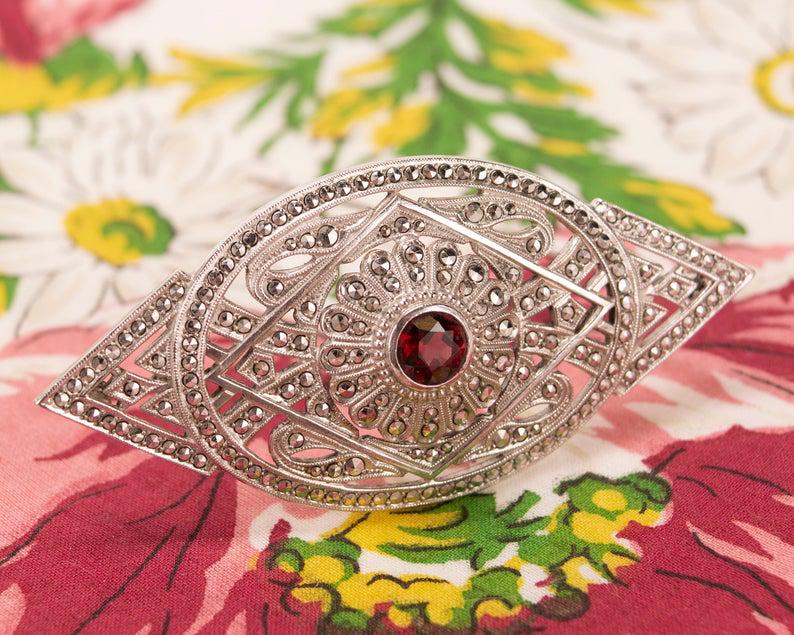 Art Deco Sterling, Marcasite & Garnet Rhodium Pin: Antique Art Deco Sterling Silver, Marcasite & Garnet Rhodium Plated Brooch Pin. This fabulous, marquise shaped Deco brooch is in excellent condition. Fashioned from rhodium plated sterling silver, its