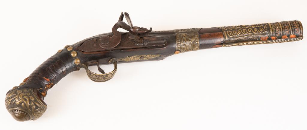 Antique Turkish Black Powder Pistol: Item/Description: 19th century Turkish flintlock pistol with brass nail head and overlay and leather on wooden stock. Material: N/A Dimensions: Length: 16"; Width: 5 1/2". Condition: Not working. Wear