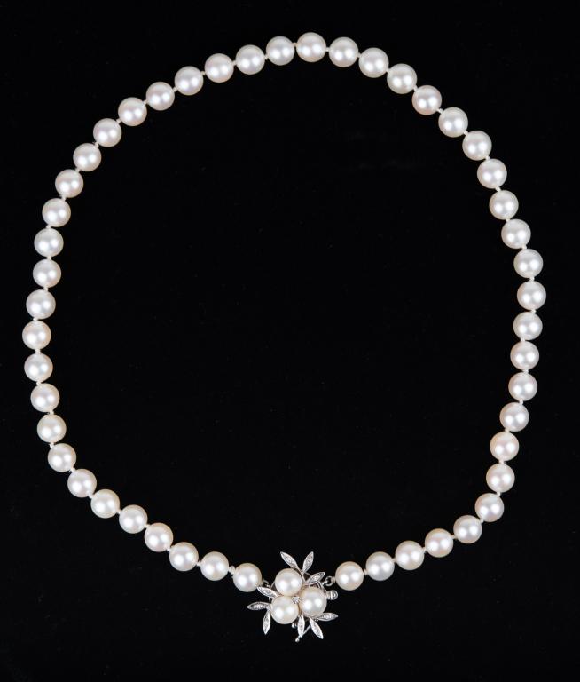 14K White Gold & Diamonds Akoya Pearl Necklace: Item/Description: Lustrous strand of soft white Akoya pearls. Strung on knotted silk thread. 14K White Gold floral clasp sprinkled with nine diamonds and topped with a trio of pearls. Safety hinge. Cl