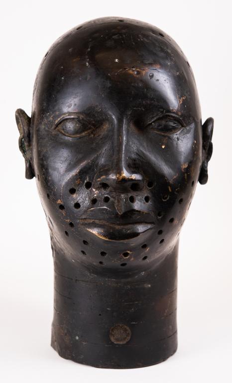 African Bronze Head, Oni Ife Nigeria: Item/Description: Bronze head with pierced holes, grooves around neck and large open hole in back. The various holes that dot the face were originally ornamented with small pearls, perhaps intended as