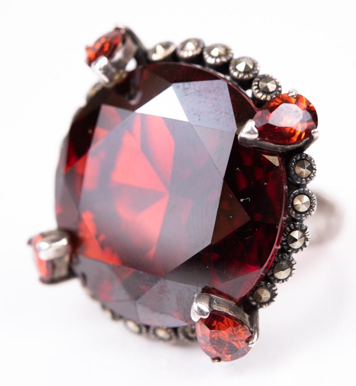 Huge Glass Garnet & Marcasite Sterling Ring: Item/Description: This amazing ring boasts a huge faceted round glass garnet, accented by four pear-shaped glass garnets and ringed by hand-set marcasites. Raised mounting. Ornate, basket setting allo