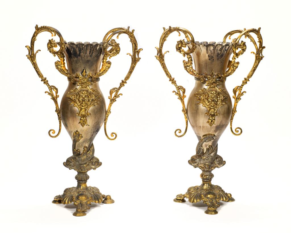 Pair of 19th Century French Poseidon Urns: Item/Description: Brushed & gilt mixed metal baroque style tall urn with mythical Greek theme. Scrolled ornate handles featuring four griffins. Decoration on both sides includes a large face of Poseid