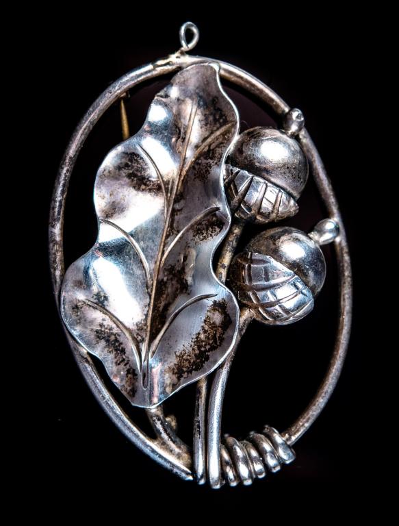 Georg Jensen USA Sterling Oak Leaf Acorn Pin: Item/Description: Lovely, hand-wrought Nouveau-esque brooch with a pair of three dimensional acorns nestled against an oak leaf. Fluid design in open oval Sterling wire frame. Small loop at end of pen